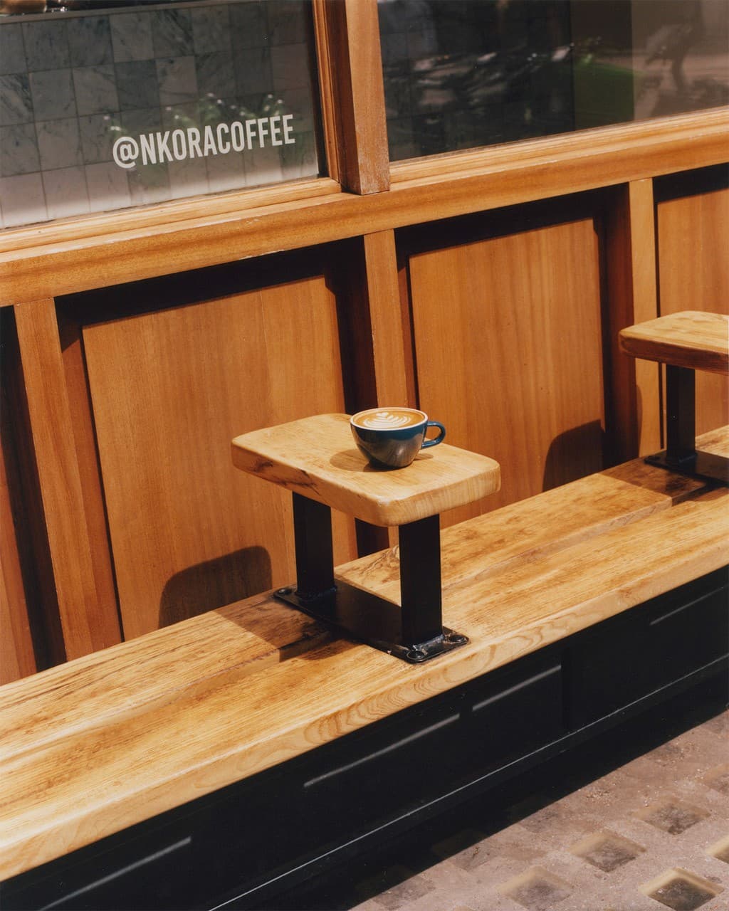 Coffee cup outside NKORA shop window